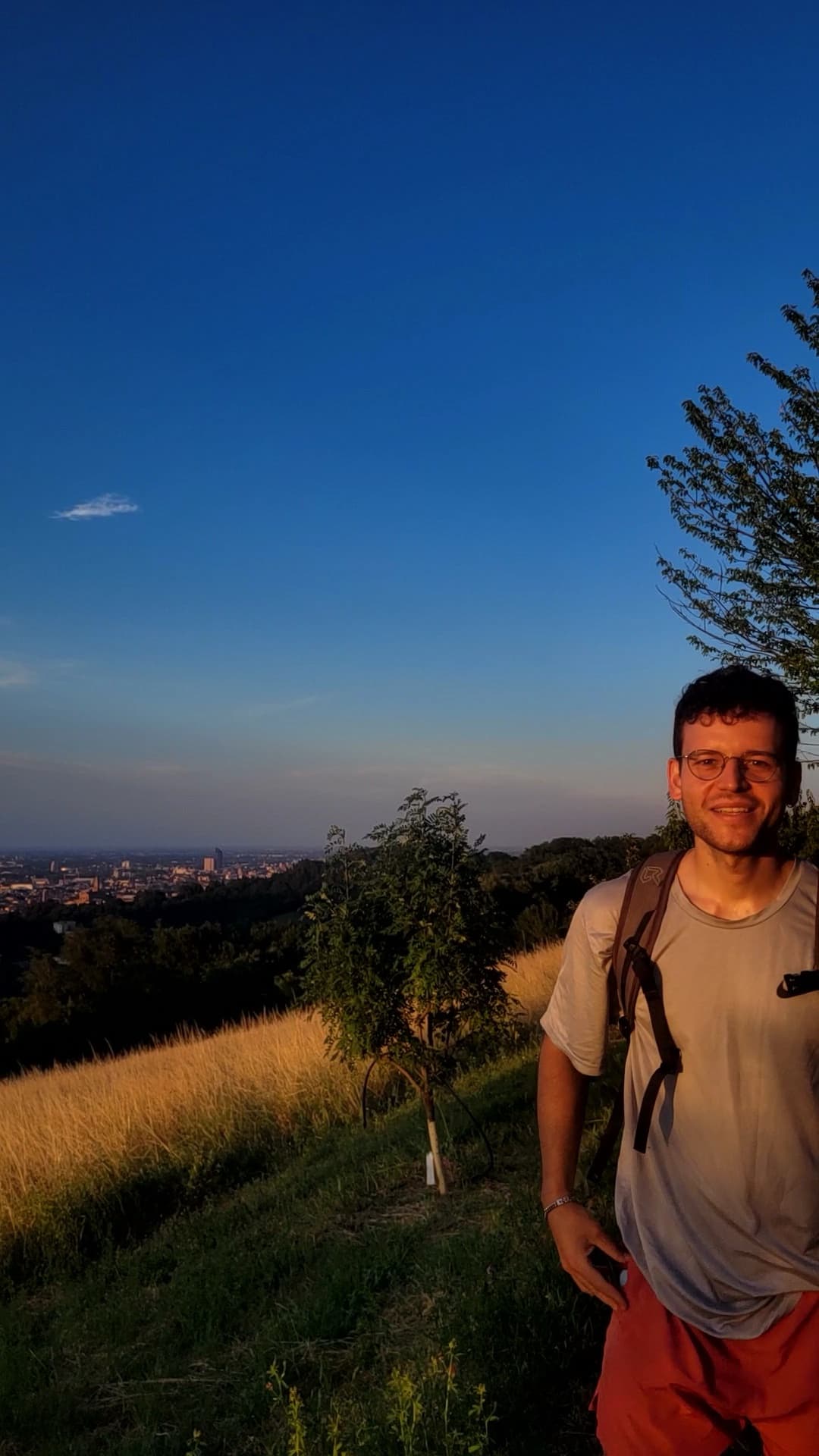 Marcello standing on a hillside overlooking Bologna in the evening sun.